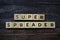 Super Spreader word letter on wooden background