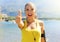 Super woman! Portrait of winner girl showing thumb up. Positive smiling fitness woman outdoor. Happy beautiful fitness woman
