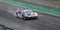 Supercar Ferrari GT racing action on wet raining asphalt straight track circuit