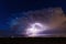 Supercell storm clouds illuminated by lightning strikes