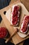 Superfood dessert flat lay. Chia seed raspberry jam with flax seeds and ricotta on wholegrain crispbread on wooden boards