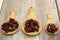 Superfoods, cranberry, raisins, and sunflowers on wooden spoons.