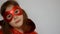 Superhero Cute Baby Girl. Funny child in a red raincoat and mask playing power super hero. Portrait close up.