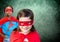 Superhero kids in front of green background