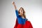 Superhero Woman. Young and beautiful blonde in image of superheroine in red Cape growing. Onward and upward