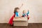 Superheroes children playing in cardboard box