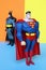 Superman and Batman on pastel colors background.