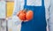 Supermarket clerk holding tomatoes