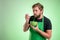 Supermarket employee with green apron and black t-shirt cool the soup, hold the bowl in his hand