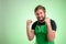 Supermarket employee with green apron and black t-shirt raised fists up exclaiming with joy and excitement