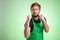 Supermarket employee with green apron and black t-shirt showing fists