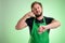 Supermarket employee with green apron and black t-shirt showing it`s time gesture