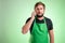 Supermarket employee with green apron and black t-shirt talking on cellphone