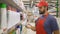 Supermarket employee in red uniform scanning cleaners barcode in modern retail store