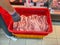 Supermarket employee stocking raw pork meat into cooler or freezer