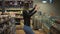 At the supermarket: happy young girl funny dancing between shelves in supermarket. Blonde girl wearing jeans and black