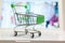 Supermarket shopping cart on laptop background close-up, macro, online shopping concept and purchasing power, consumer shopping
