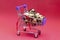 Supermarket trolley with eggs on a red background. Preparing for the Easter holidays. The photo