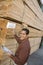 Supervisor Checking Label On Stack Of Wood