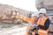 Supervisor showing something to coworker holding laptop at construction site