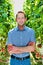 Supervisor standing with arms crossed in greenhouse