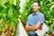 Supervisor standing with arms crossed at greenhouse