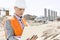 Supervisor using laptop at construction site on sunny day