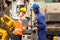 Supervisor, worker with hard hat working in manufacturing factory on business day