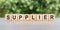 SUPPLIER word made with building blocks on a light background