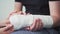Support and care for the patient with a broken arm. The hand is in gypsum. Rehabilitation after injury, physiotherapy