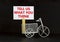 Support symbol. Wooden clothespin with white sheet of paper. Words `tell us what you think`. Miniature bicycle model. Beautiful
