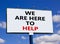 Support symbol. Words `we are here to help` on white billboard. Beautiful blue sky. Business and support concept. Copy space