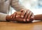 Support, unity and trust by a couple feeling grief due to cancer holding hands together on a table. Closeup of an