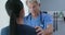 Supportive male doctor with hand on shoulder of female patient in hospital