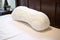 a supportive sleeping aid pillow gently cradled on a bed