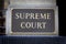 Supreme Court sign on a pillar closeup.