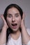 Suprised brunette woman, isolated on gray background. happy actress portrait. human emotions, facial expression concept