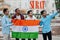 Surat city inscription. Group of four indian male friends with India flag making selfie on mobile phone. Largest India cities