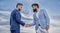 Sure sign you should trust business partner. Men formal suits shaking hands blue sky background. Business deal approved