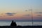 Surf angler with fishing rod on the baltic sea beach at sunset