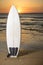 Surf board on the beach by sunset