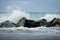 Surf breaking over rocks in a cloud of spray