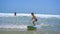 Surf instructor teaches little boy how to surf. Slowmotion shot