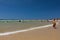 A surf lifesaver patrols crowded beach in summer as people enjoy swimming and playing in the ocean and sand