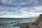 Surf spot with waves on atlantic ocean in colorful sky with clouds