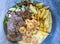 Surf and Turf recipe consisting of grilled steak fillets, cooked shrimps, potato fries, and a creamy cheese sauce