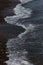 The surf wave line on a dark pebble beach in the evening