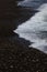 The surf wave line on a dark pebble beach in the evening