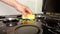 Surface cleaning, woman washing gas stove with yellow washcloth and detergent