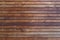 Surface of a freshly painted planking of a facade of wooden slats in the color mahogany